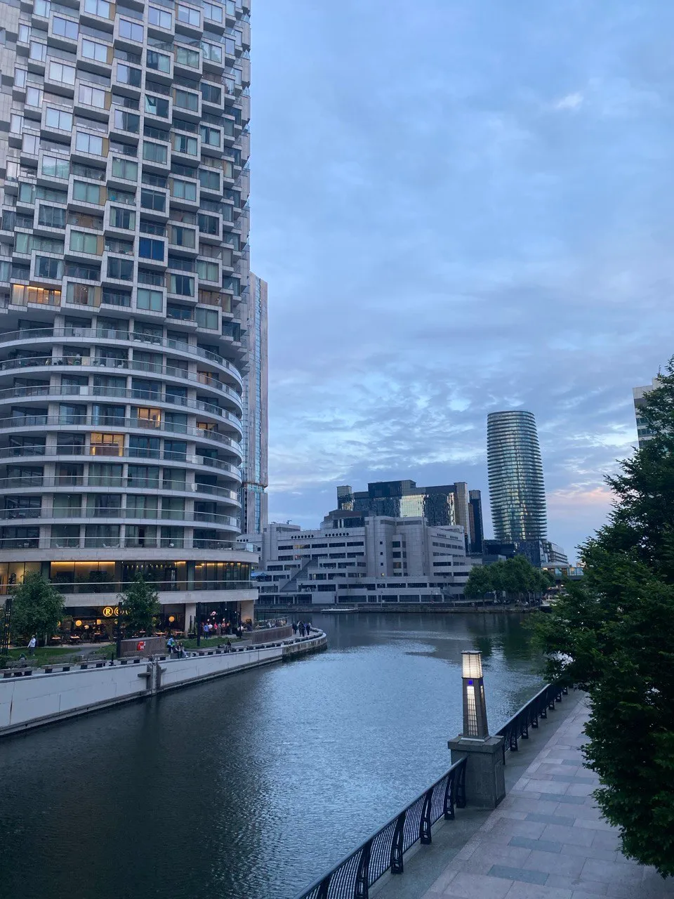 a view of Canary Wharf, tall glass building around a quiet canal